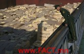 A Chinese frontier policeman checks sacks of rice from South Korea, which will be sent to North Korea, at Dandong port,