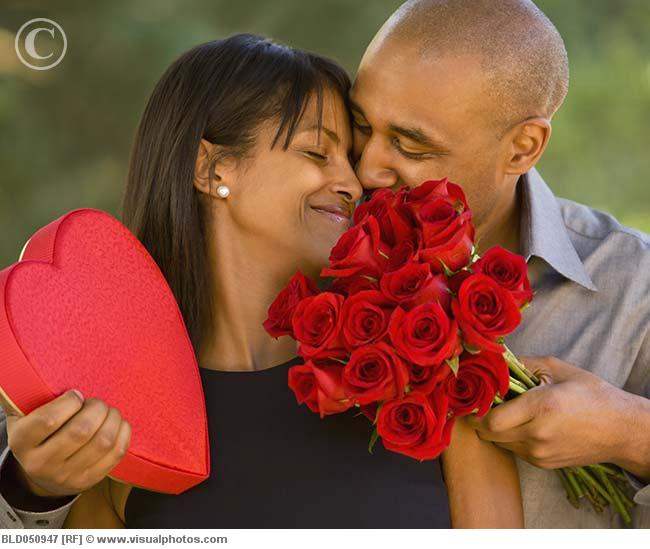 African American man giving Valentine's Day gifts to wife