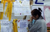 A mother whose teenage child was onboard the capsized Sewol ferry and is missing, cries as she reads messages dedicated to the missing and dead passengers on the ship at a port in Jindo