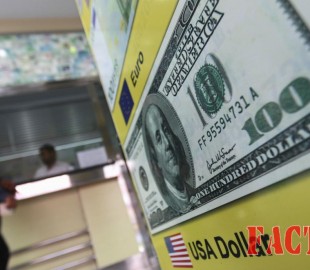 A man stands next to a money changer in Colombo