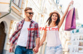 We love shopping together! Beautiful young loving couple walking by the street while beautiful woman carrying shopping bags and smiling