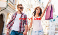 We love shopping together! Beautiful young loving couple walking by the street while beautiful woman carrying shopping bags and smiling